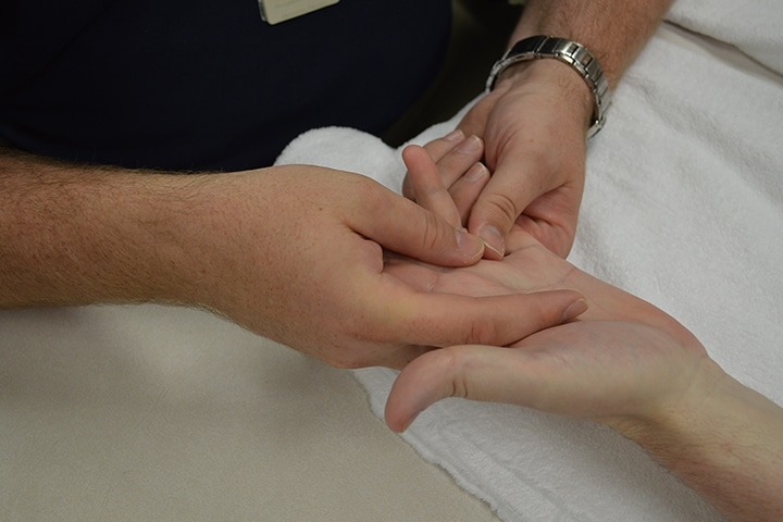 Hand therapist performs therapy on patient