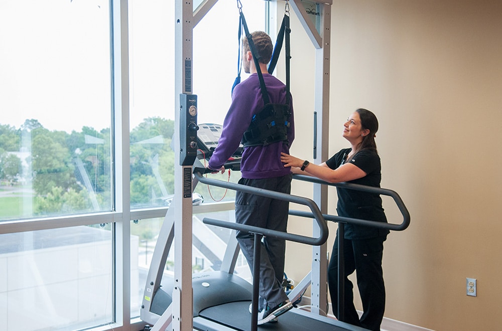 Rehab Nurse Helping Patient on Spinal Unweighting System