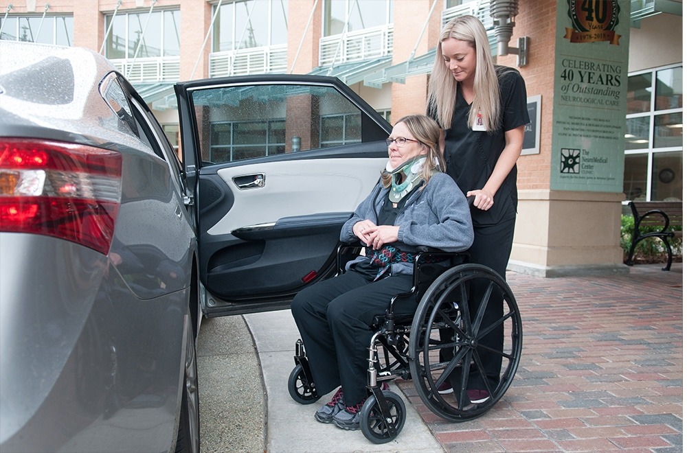 Inpatient Nurse Helping Patient to Vehicle