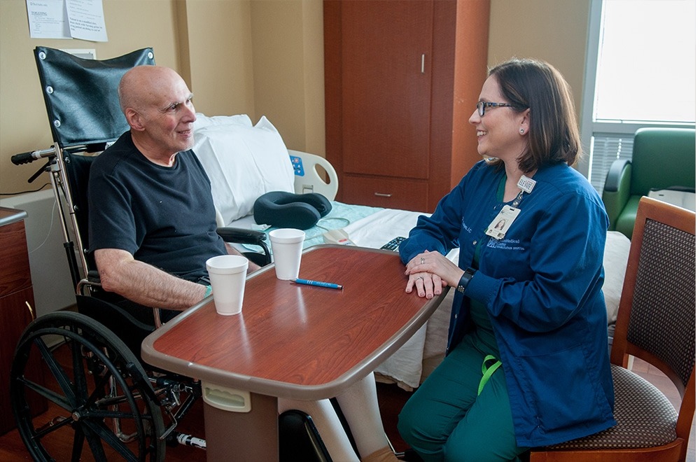 Inpatient Nurse Visiting with Patient in Rehab Hospital