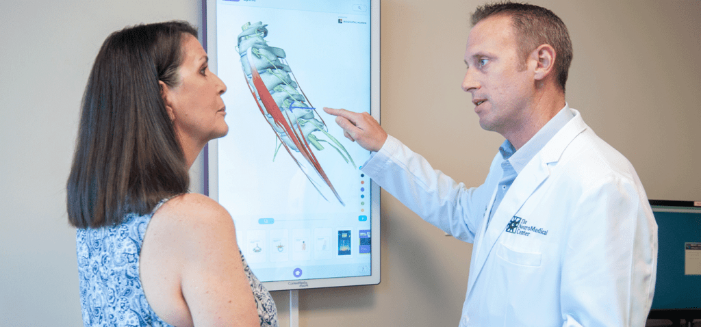 neurosurgeon explains spinal issue with patient
